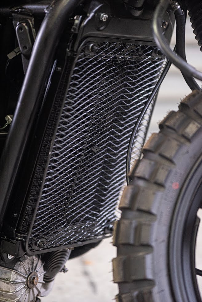 Détail du radiateur de la moto avec grille métallique.